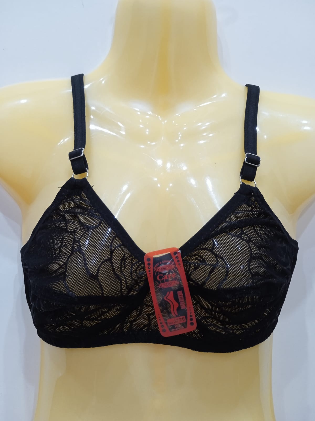 Black lace bra on a mannequin with a visible brand tag against a white background